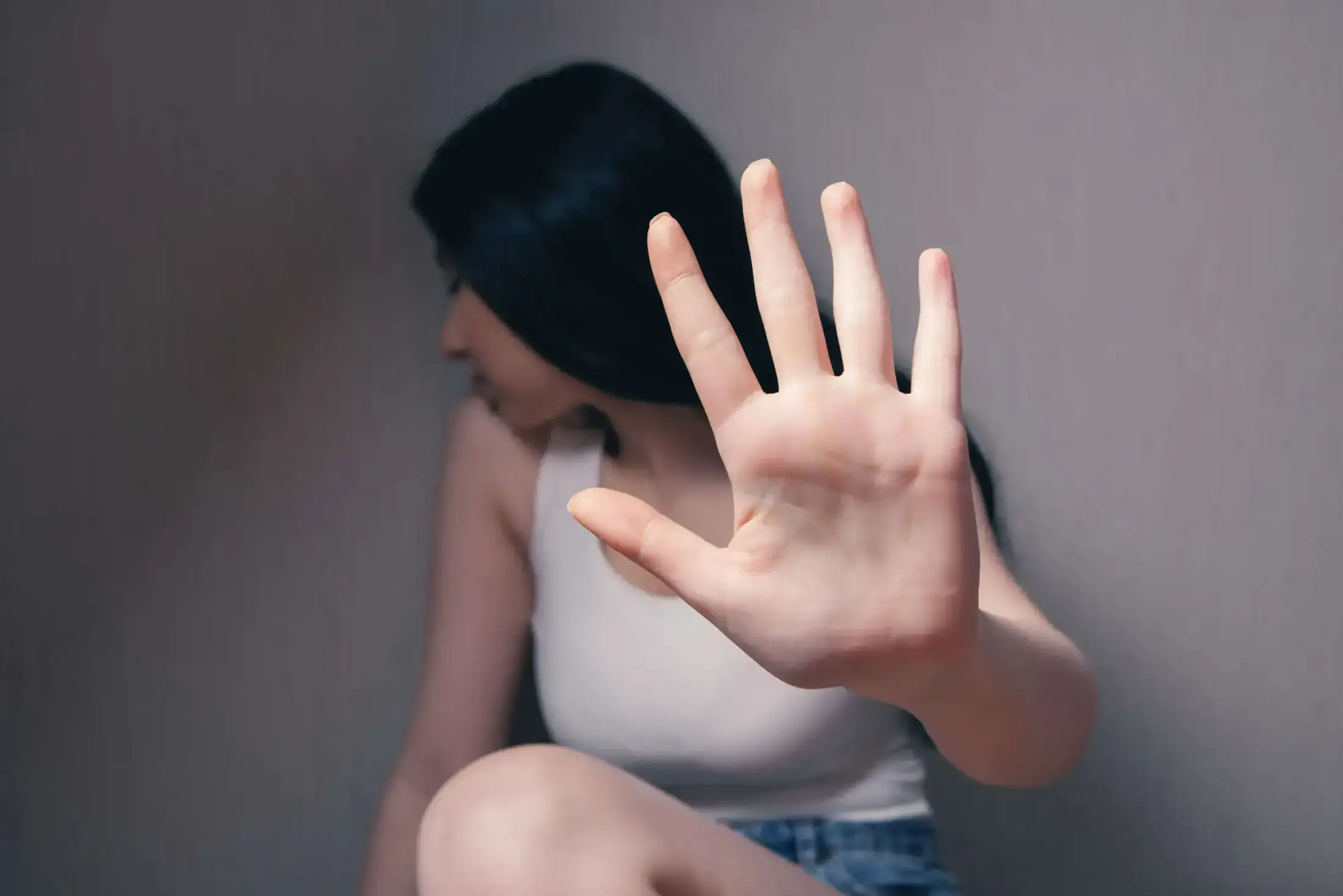 A woman holding up her hand in a stop gesture.