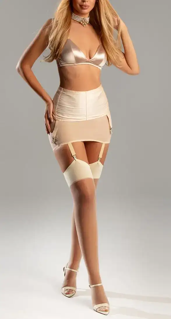 Woman wearing a champagne satin lingerie and suspender set.
